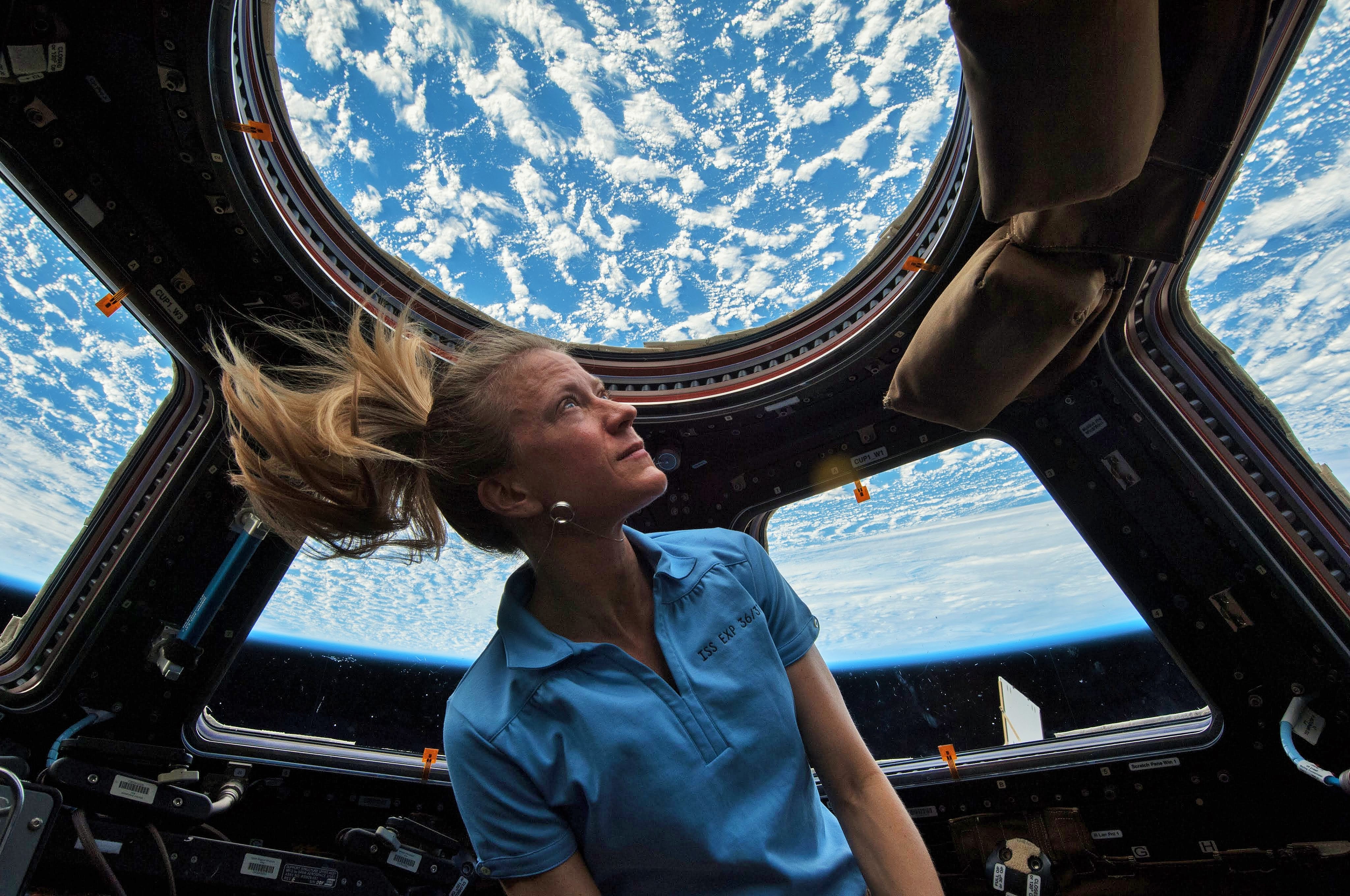 NASA Astronaut Karen Nyberg in the cupola module on the International Space Station (ISS). She has a degree in mechanical engineering and her studies centered on human thermoregulation and experimental metabolic testing and control, and focusing on the control of thermal neutrality in space suits.